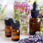 This is an image of essential oil bottles nestled between lavender and other plants