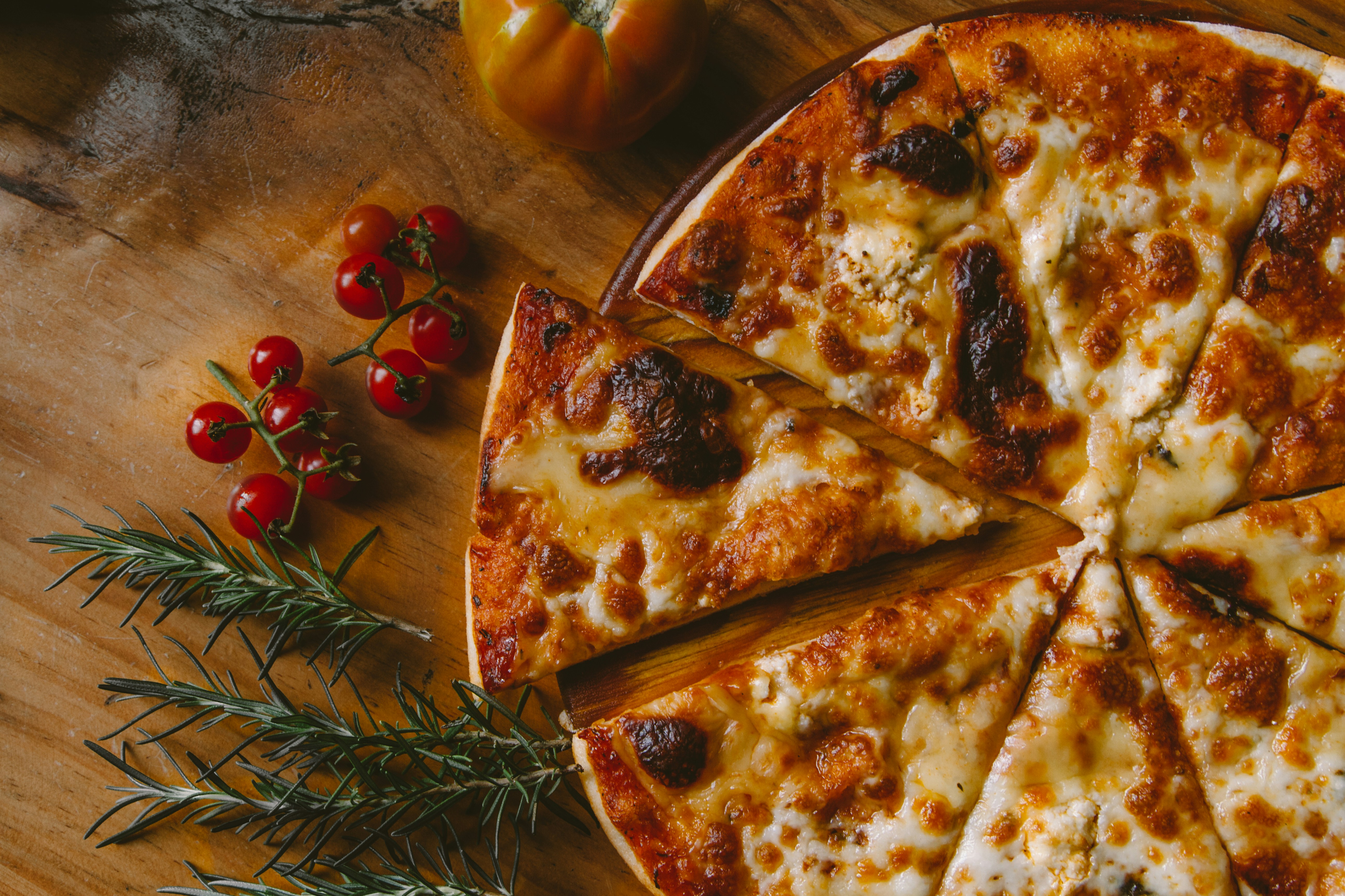 pizza with some cherry tomatoes on the side