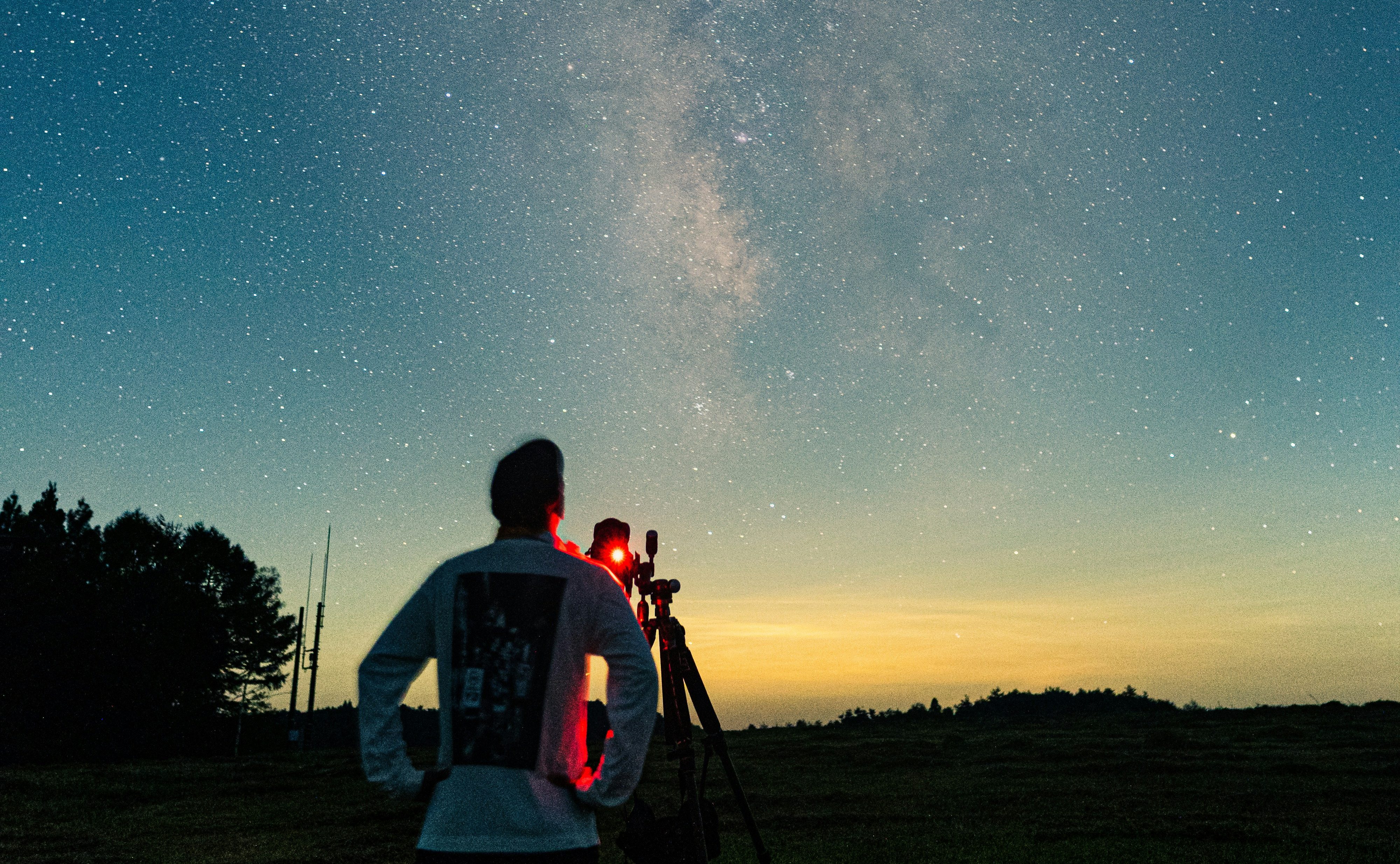 man looking in the sky with telescope stargazing