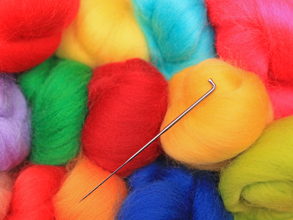 several bunches of wool with needle in front